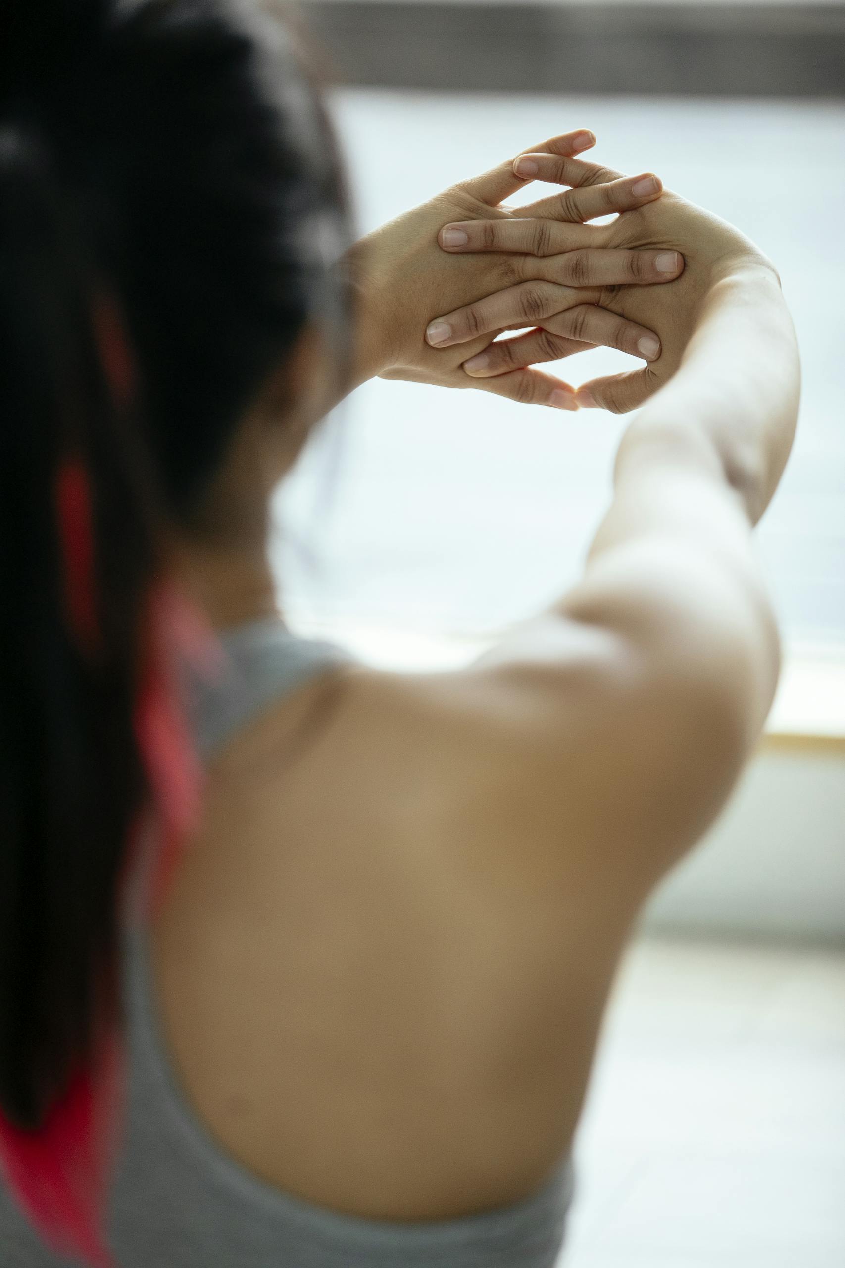 Close-up of a woman stretching her arms for fitness indoors.